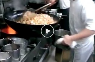 Китайский шеф-повар жарит большую порцию мяса с овощами на воке