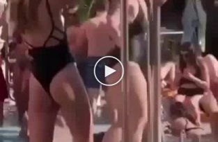 Девушка возле бассейна осваивает шест