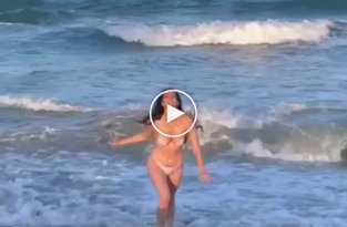 Девушка бежит с моря на берег